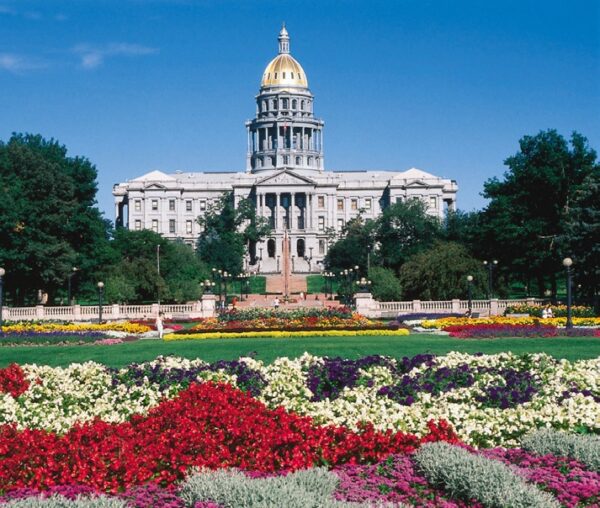 Denver Colorado Gold Domed Capitol Building behind a manicured garden of colorful flowers